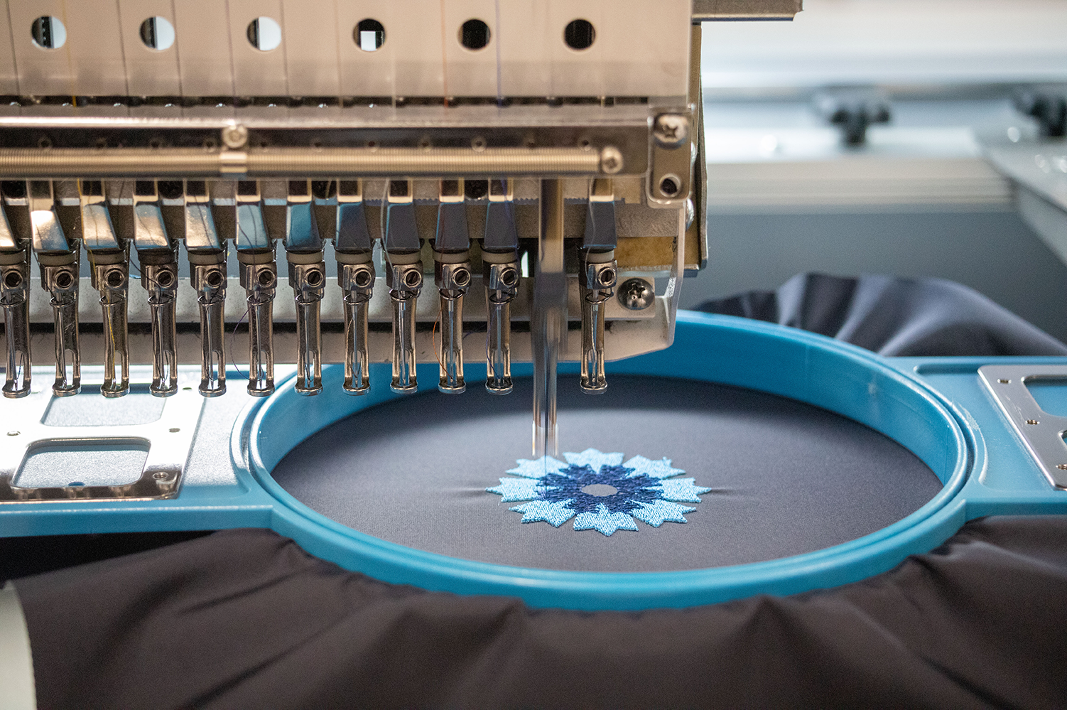 La machine à broder du Parpapluie de Cherbourg laisse apparître un Bleuet de France.